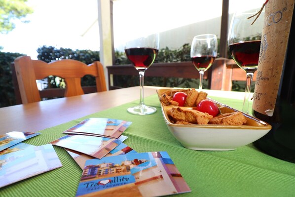 A table with a bowl of food, two wine glasses, and brochures.