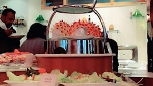 A buffet setup with multiple serving stations, including a tiered display for desserts and a variety of food items. - Zone Connect Darjeeling (Darjeeling)