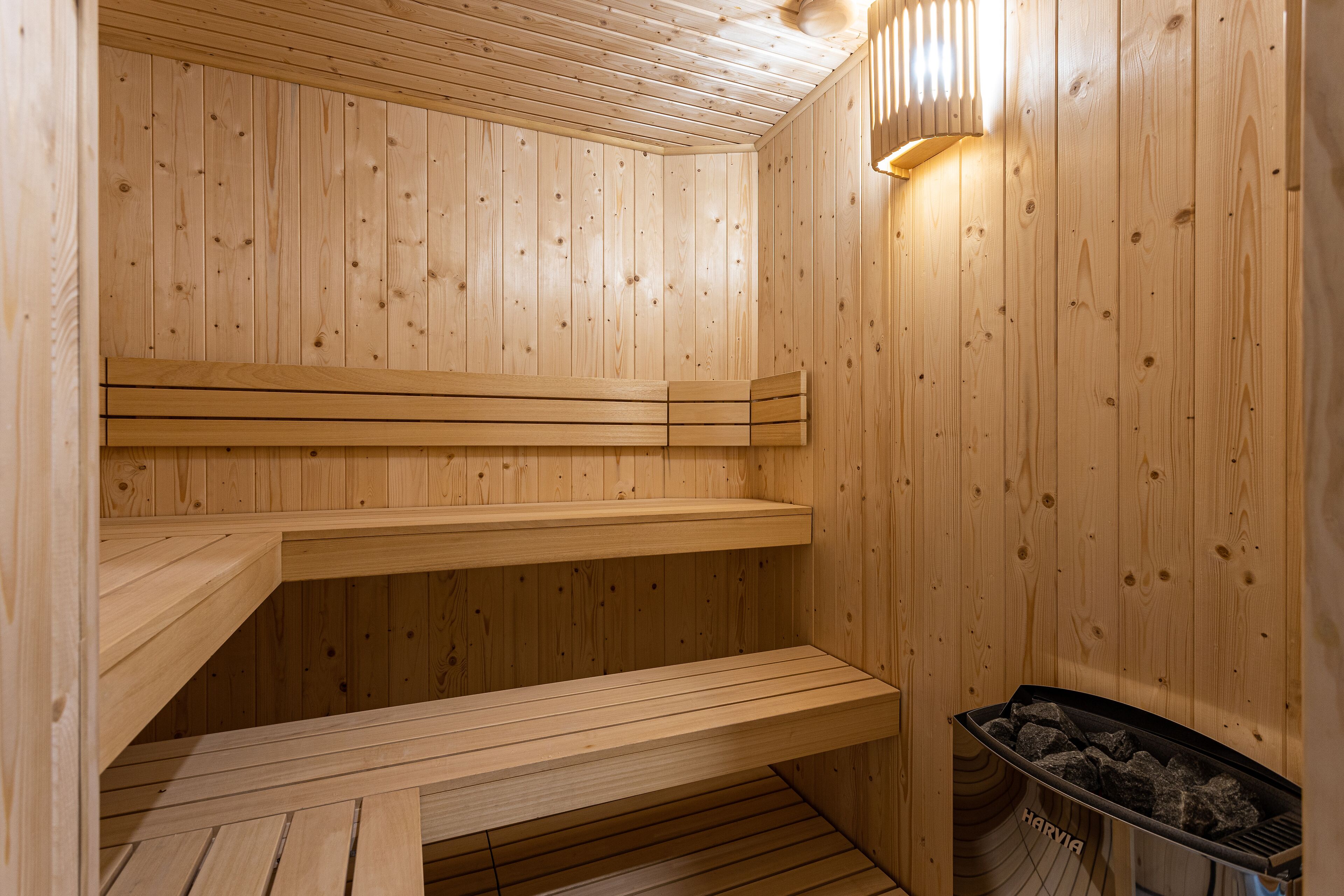 A wooden sauna with benches and a visible wood-burning stove.