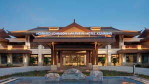 The Howard Johnson Lakeview Hotel Kunming exterior with a large entrance, a swimming pool, and a well-lit facade.
