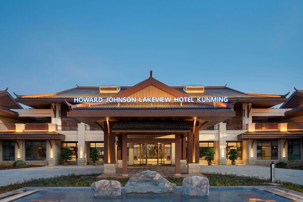 Exterior del hotel Howard Johnson Lakeview Kunming con una entrada amplia, piscina y fachada bien iluminada.