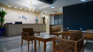 A hotel lobby with a reception desk, seating area, and a chandelier. - Hwangsil Tourist Hotel (Jeonju)