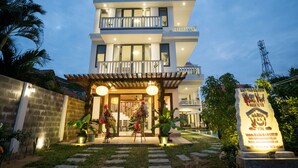 A modern two-story villa with a balcony, a well-lit entrance, and a signboard. - Hoi An Maison Vui Villa (Da Nang Municipality)