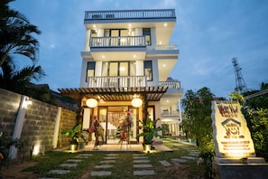 Stunning hotel exterior with a welcoming entrance, decorative archway, and beautiful garden.