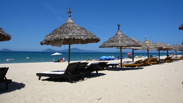 A beach with thatched umbrellas and sun loungers. - Hoi An Maison Vui Villa (Da Nang Municipality)