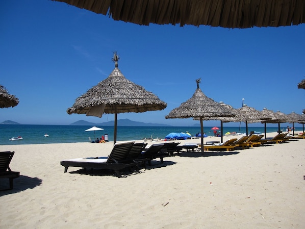 Relax on the pristine beach with comfortable sun loungers and shaded umbrellas.