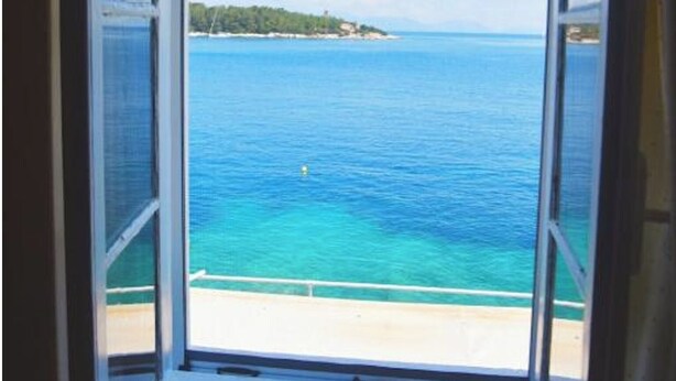 Una habitación con un ventanal que ofrece vistas a una playa y al océano.