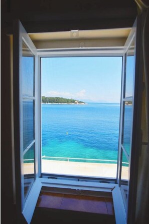 Enjoy a serene view of the sea and distant shoreline from this room's large window.