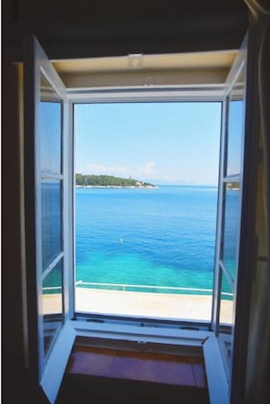Enjoy a serene view of the sea and distant shoreline from this room's large window.