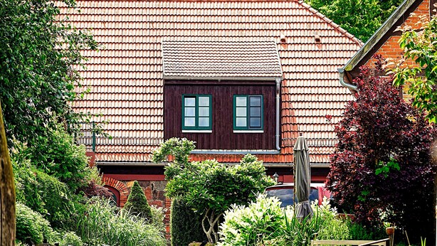 A traditional house with a tiled roof, a wooden door, and a window.