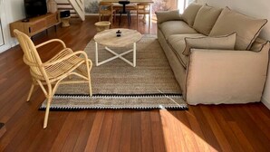 Amplia sala de estar con escalera, comedor y sofá.