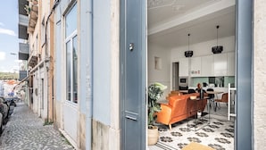 A narrow cobblestone street leading to a modern apartment with a kitchen, dining area, and a balcony with a view of the street. - Ruby Orange Apartment, WiFi, AC !New! (Lisboa)