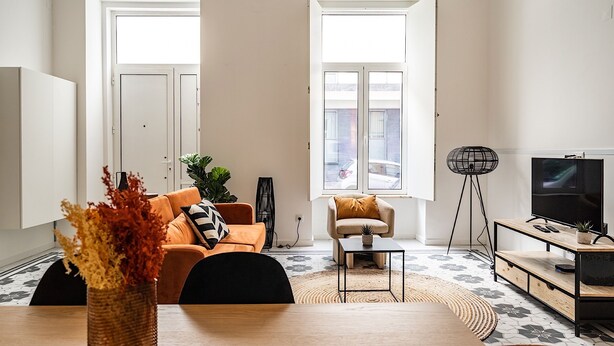 A modern living room with a sofa, armchair, coffee table, and a TV on a wooden stand. - Ruby Orange Apartment, WiFi, AC !New! (Lisboa)