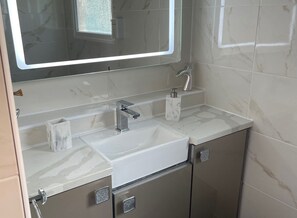 A modern bathroom with a large mirror, a sink, and a toilet. - Jjslodge Luxury Chalet in Kilkhampton Bude (Bude)