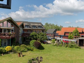 Een woonwijk met meerdere huizen, een gazon en een klein parkeerterrein.