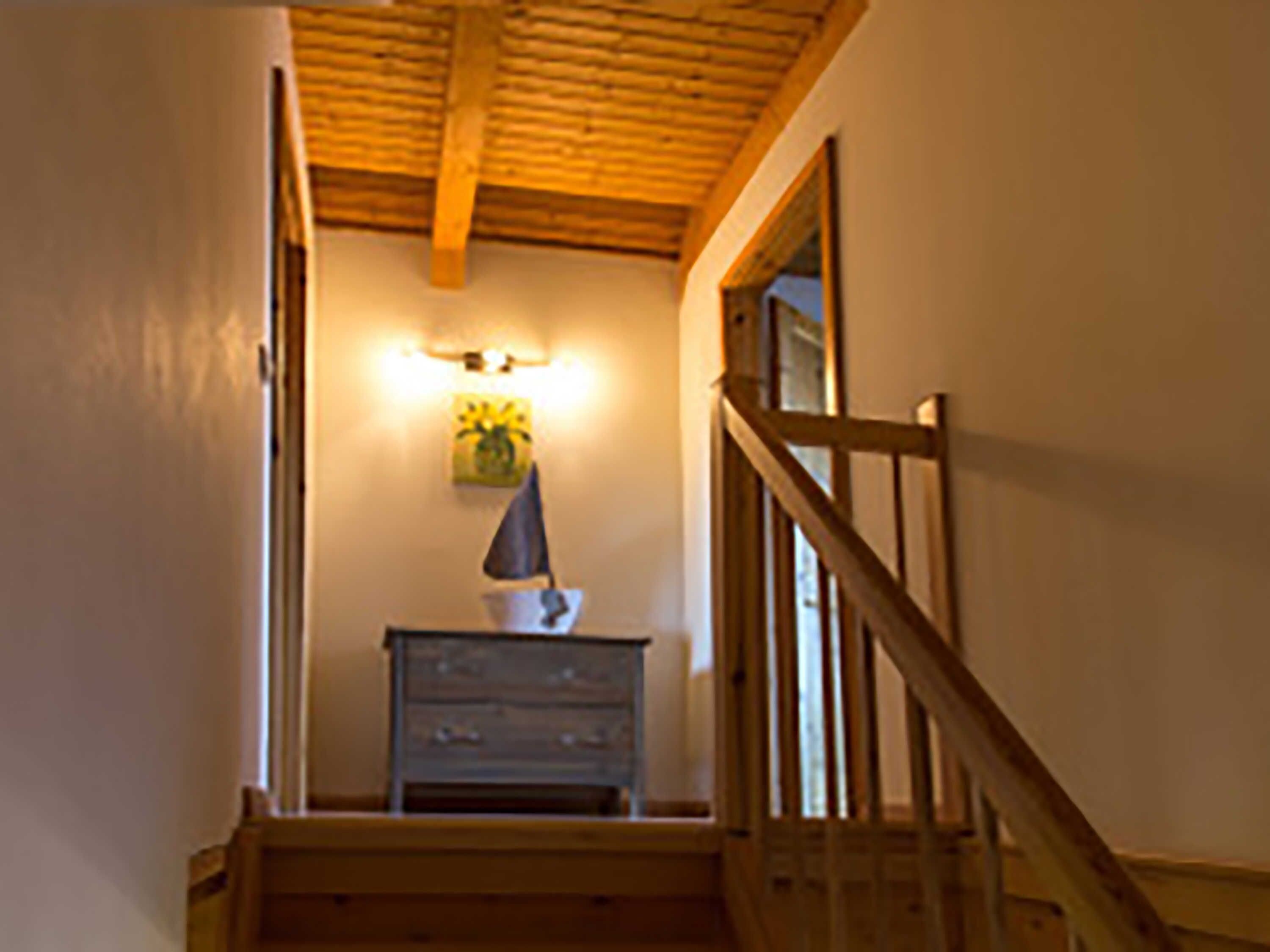 Un escalier avec des rampes en bois menant à l’étage supérieur.