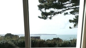 Un balcón con vista al mar y la costa lejana.