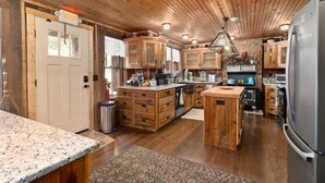 A spacious kitchen with wooden cabinets, a granite countertop, and a stainless steel refrigerator. - Glen Choga Lodge (Topton)
