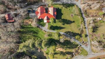 An aerial view of a property with multiple buildings, a winding road, and a river.
