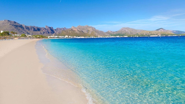 A beach with clear turquoise water, a sandy shore, and mountains in the background. - Ca'l Gall - Two Bedroom Villa, Sleeps 4 (Crestatx)
