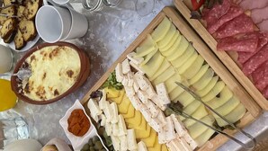 Ein Buffet mit verschiedenen Speisen, darunter Aufschnitt, Käse und Gemüse.