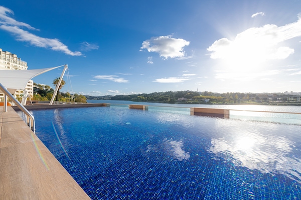 Een binnenzwembad, een buitenzwembad en parasols bij het zwembad