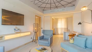 Uma sala de estar moderna com sofá, poltrona e mesa de centro redonda com um livro.