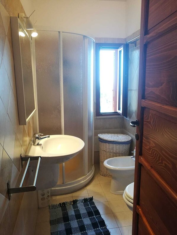 A bathroom with a bathtub, a toilet, a sink, a shower, and a window. - Villa Marina on the waterfront I.U.N. code R9661 (Magomadas)