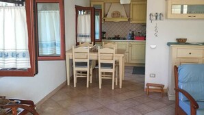 A compact living space with a dining area, kitchenette, and a small seating area. - Villa Marina on the waterfront I.U.N. code R9661 (Magomadas)