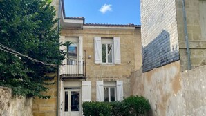 Un sendero de madera estrecho que conduce a un edificio con balcón y puerta.