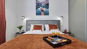 A hotel room with a bed, a breakfast tray, a plant, and a painting on the wall. - Blue fantasy is new modern villa 5 min from the beach! (Kaštel Novi)