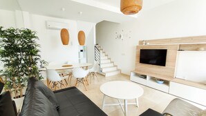 Una sala de estar moderna con un sofá, una mesa de comedor y un televisor.