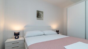 A neatly arranged bedroom with a bed, bedside tables, and a wall-mounted artwork. - IGNACIJA 1 - Apartment 3+1 people, sea view terrace (Okrug Gornji)