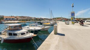 A marina with several boats docked, a concrete walkway, and a signboard. - IGNACIJA 1 - Apartment 3+1 people, sea view terrace (Okrug Gornji)