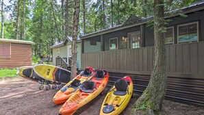 Kayaks parked near a cabin in a wooded area.