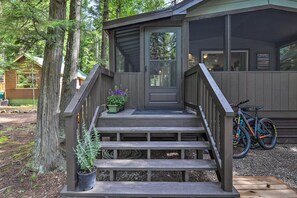 A wooden cabin with a porch, steps, and a door. There are bicycles parked outside. - West Glacier Bear Cabin In Glacier National Park (Flathead County)