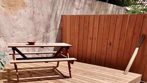 A wooden deck with a picnic table and benches.