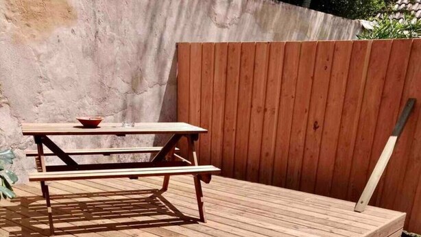 A wooden deck with a picnic table and benches. - Magnificent T3 apartment in the heart of Bordeaux (Bordeaux)