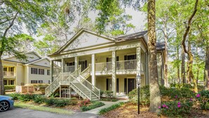 A two-story house with a front porch, a staircase, and a driveway. - PP 200-2 Golfers Paradise in Pawleys Plantation (Pawleys Island)
