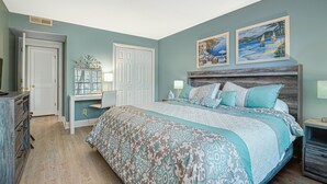 A bedroom with a bed, dresser, desk, and artwork on the wall. - PP 200-2 Golfers Paradise in Pawleys Plantation (Pawleys Island)