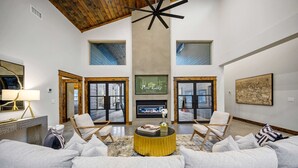 A spacious living room with a fireplace, a large sofa, and two armchairs. - New and modern cabin with luxury shower room and hot tub (Broken Bow)