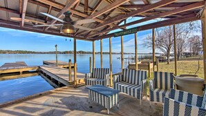 Un espacio de estar al aire libre techado con vista a un lago, muelle de madera y un letrero que dice "Northwest Hwy 9600".