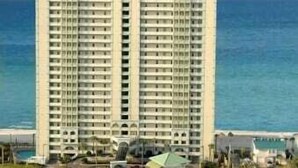 A high-rise hotel with multiple balconies, a flat roof, and a view of the ocean. - Gulf front end unit w/ wraparound balcony, Sunset ocean views, 3BR 3BA! (Panama City Beach)