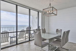 Enjoy meals in this stylish dining area with a large table and comfortable seating for six, offering a view of the ocean from the adjacent balcony.