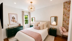 A bedroom with a large bed, bedside tables, a mirror, a dresser, and a chair. - Casa Clarkson
Mid-century modern getaway in West LA. Close to beach & shops. (Los Angeles)