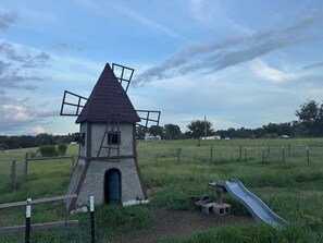 A windmill with a ladder and a slide in a grassy field. - Relaxing Cottage Near Fishhawk (Lithia)