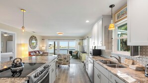 A spacious kitchen with a large island, a dining area with a view, and a cozy seating area. - Eastern Lake Home + Dock - Walk to Beach + Bikes (Santa Rosa Beach)