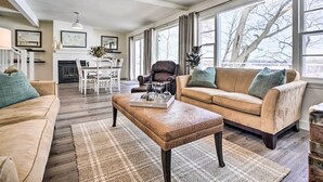 Ein geräumiges Wohnzimmer mit einem beigefarbenen Sofa, einem Holztisch und einem Kamin.