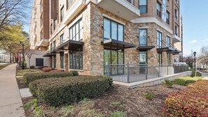 A modern building with stone facade, large windows, and outdoor seating areas. - Kasa Dilworth Charlotte (Charlotte)
