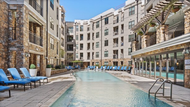 A swimming pool surrounded by lounge chairs and stone buildings with balconies. - Kasa Dilworth Charlotte (Charlotte)